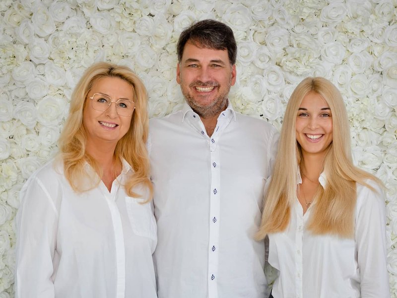 Das Team von Forever Brautmoden in Hochheim am Main vor einer Wand aus weißen Rosen